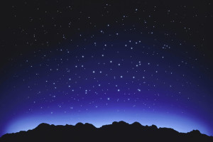 Star field over mountain range at night